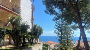 A residential area with a view of the sea, a staircase leading down, and a balcony with plants. - Lovely apartment for 4 guests with pool, A/C, WIFI and balcony (Cipressa)