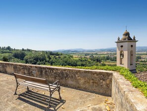 A bench overlooking a scenic landscape with a tower in the distance. - Beautiful apartment for 2 guests with pool, WIFI, TV and panoramic view (Palaia)