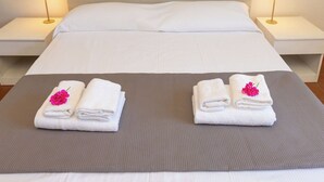 Ein Hotelzimmer mit einem Bett, zwei Nachttischen und zwei Handtüchern mit Blumen auf einer Bettdecke.
