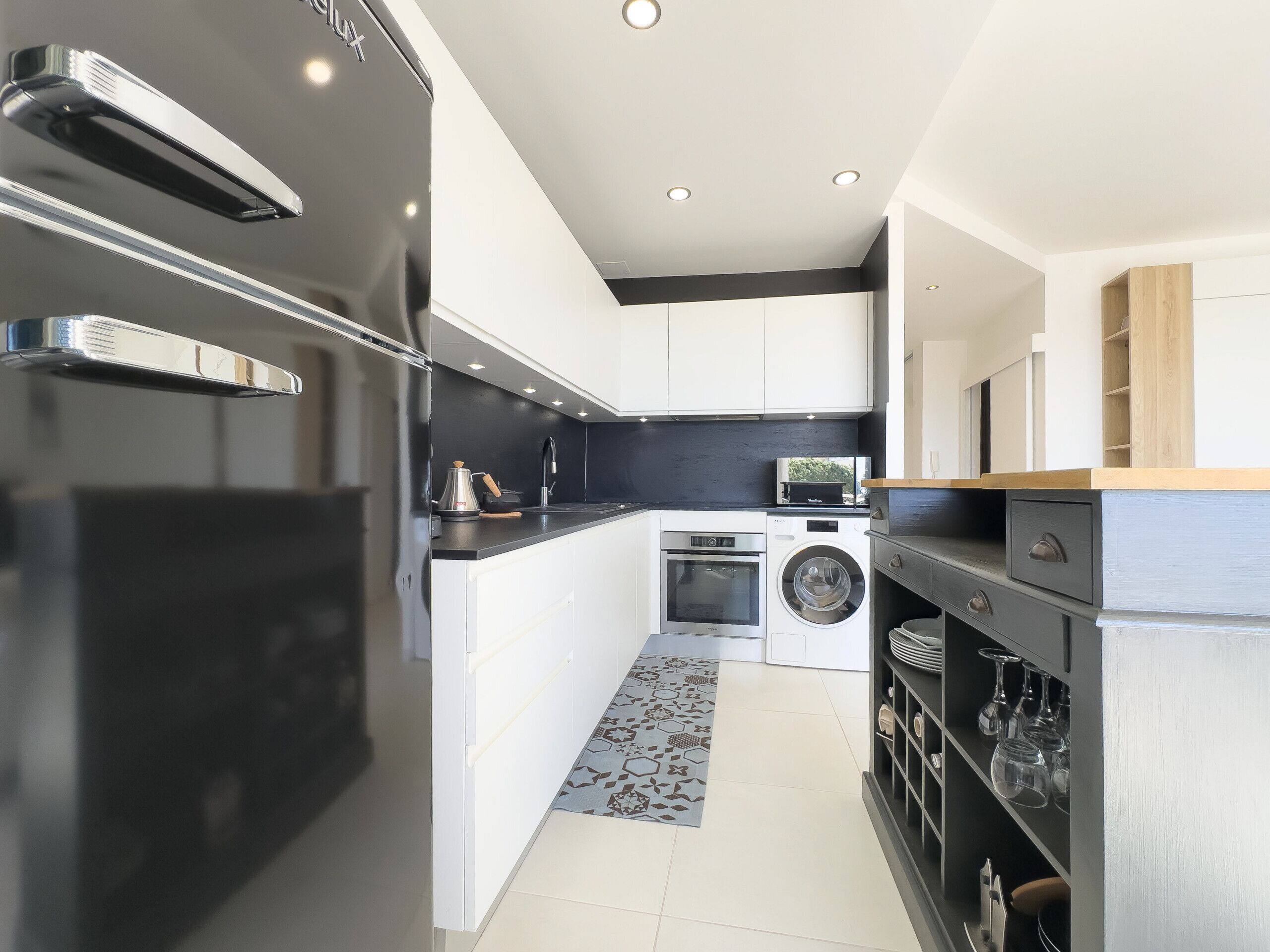 A modern kitchen with a built-in oven, microwave, and washing machine.