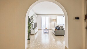 Un salon avec un canapé, un téléviseur et une plante.