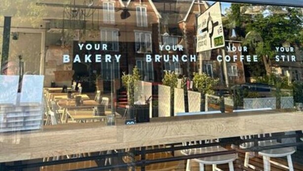 A storefront with a sign reading 'st/r MADE FOR CAMBRIDGE' and a window display advertising 'YOUR BAKERY BRUNCH COFFEE STIR.' - 1Bed Central Apt With Parking! (Cambridgeshire)