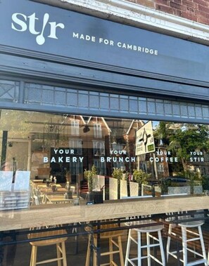 Fachada com letreiro lendo 'st/r MADE FOR CAMBRIDGE' e vitrine anunciando 'YOUR BAKERY BRUNCH COFFEE STIR'.