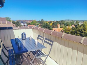 A balcony with a table and chairs, a kettle, and a mug. - L'Horizon - Appartment Bénerville sur Mer - 4 people - Balcony and parking lot (Benerville-sur-Mer)