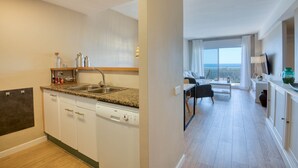 Eine moderne Küche mit Granit Arbeitsplatten, einem eingebauten Geschirrspüler und einem großen Fenster.