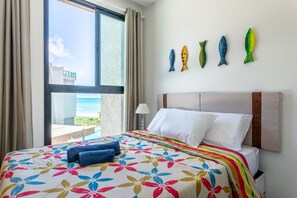 Ein Hotelzimmer mit Bett, Meerblick und Wandverziierungen mit Fischmotiven.