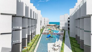 A resort with modern architecture, a swimming pool with a slide, and a view of the sea. - FlatCarneiros-Varanda com Vista-SH152 (Tamandaré)