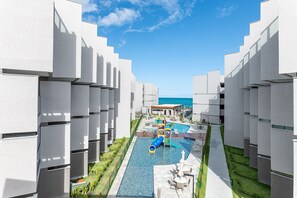 Ein Resort mit moderner Architektur, einem Pool mit Rutsche und Meerblick.