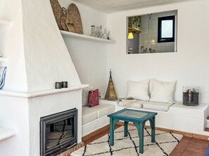 Ein Wohnzimmer mit Kamin, einer Couch, einem Couchtisch und einem Fenster mit Blick.