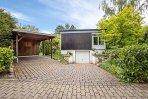A modern house with a paved driveway, a covered porch, and a garage. - Apartment Kleine Seeperle in Quickborn – Quiet, Modern, and Well Connected (Quickborn)