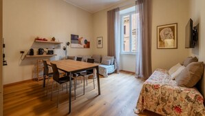 Ein gemütlicher Wohnbereich mit Esstisch, Sofa und Bett.