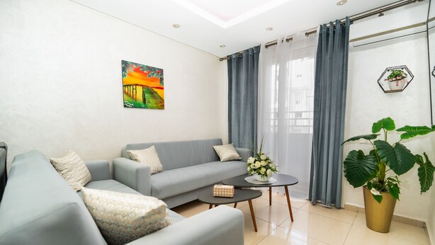 Ein Wohnzimmer mit Sofa, Couchtisch und Zimmerpflanze.