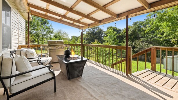 A covered patio with outdoor furniture, a grill, and a fire pit. - Cozy, Quiet 2 Bedroom with Hot Tub, Fire Pit, Close to Fayetteville (Winslow)