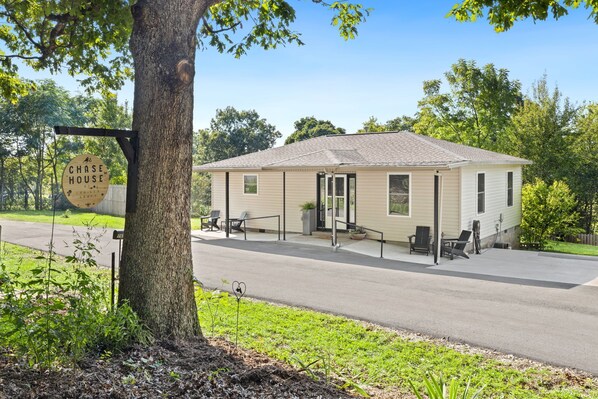 A single-story house with a covered porch, a mailbox, and a sign that reads 'CHASE HOUSE.'