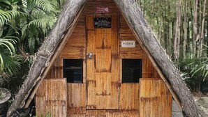 A small wooden hut with a thatched roof, surrounded by dense forest. - Soulelle Villa (Silang)