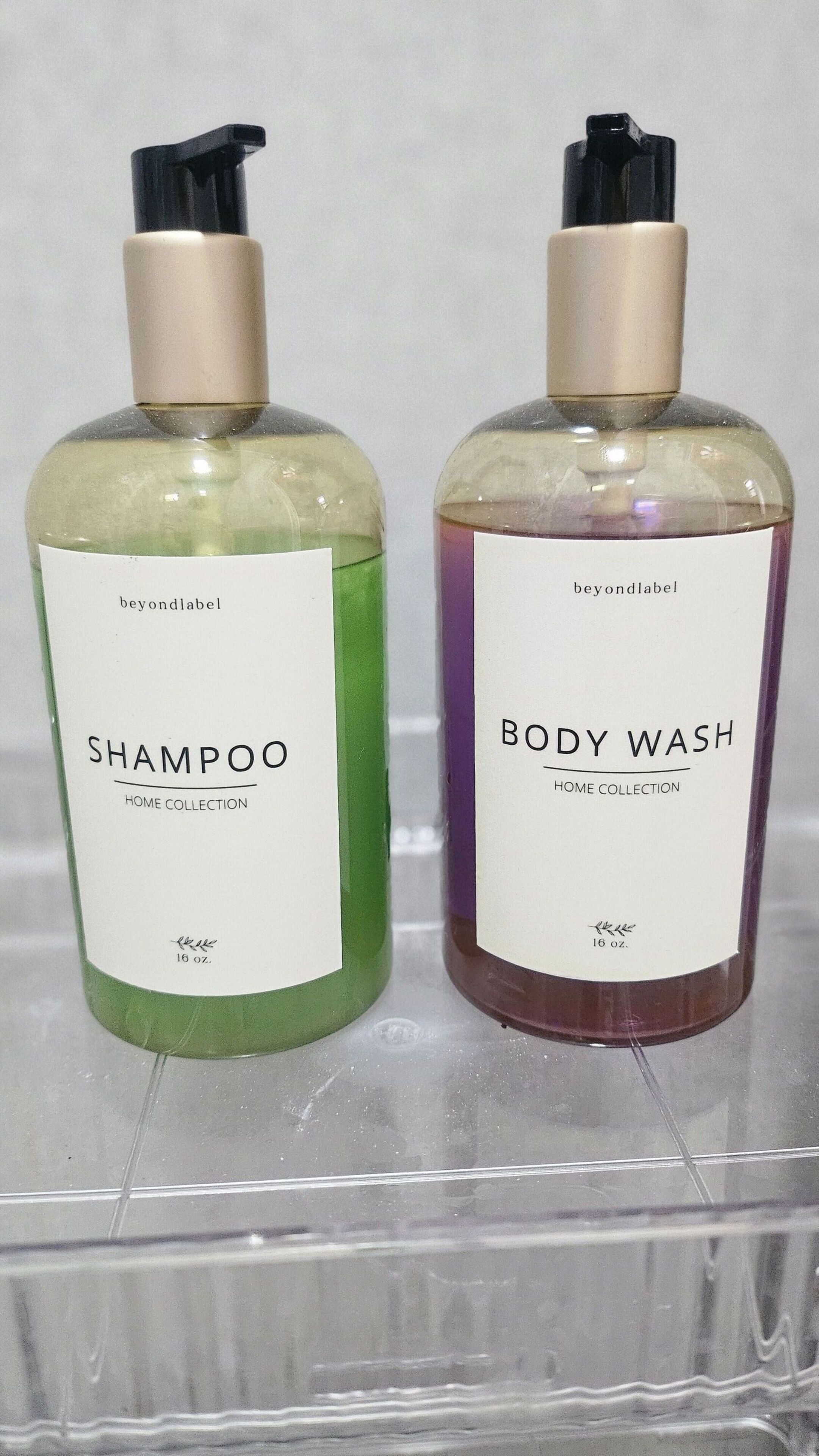 Two bottles of liquid soap labeled 'beyondlabel' and 'body wash' in a clear plastic container.