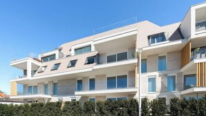 A multi-story residential building with a modern architectural design, featuring balconies, large windows, and a flat roof. - La Dolce Vickri - modern stay with garden & pool (Nieuwpoort)