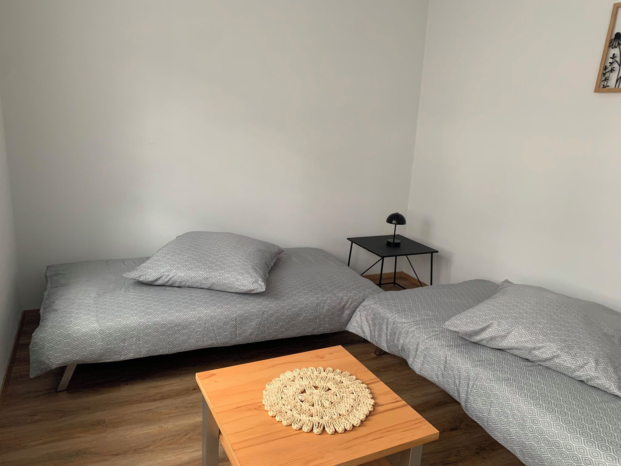 Ein Zimmer mit einem Bett, einem kleinen Tisch und einem Nachttisch.