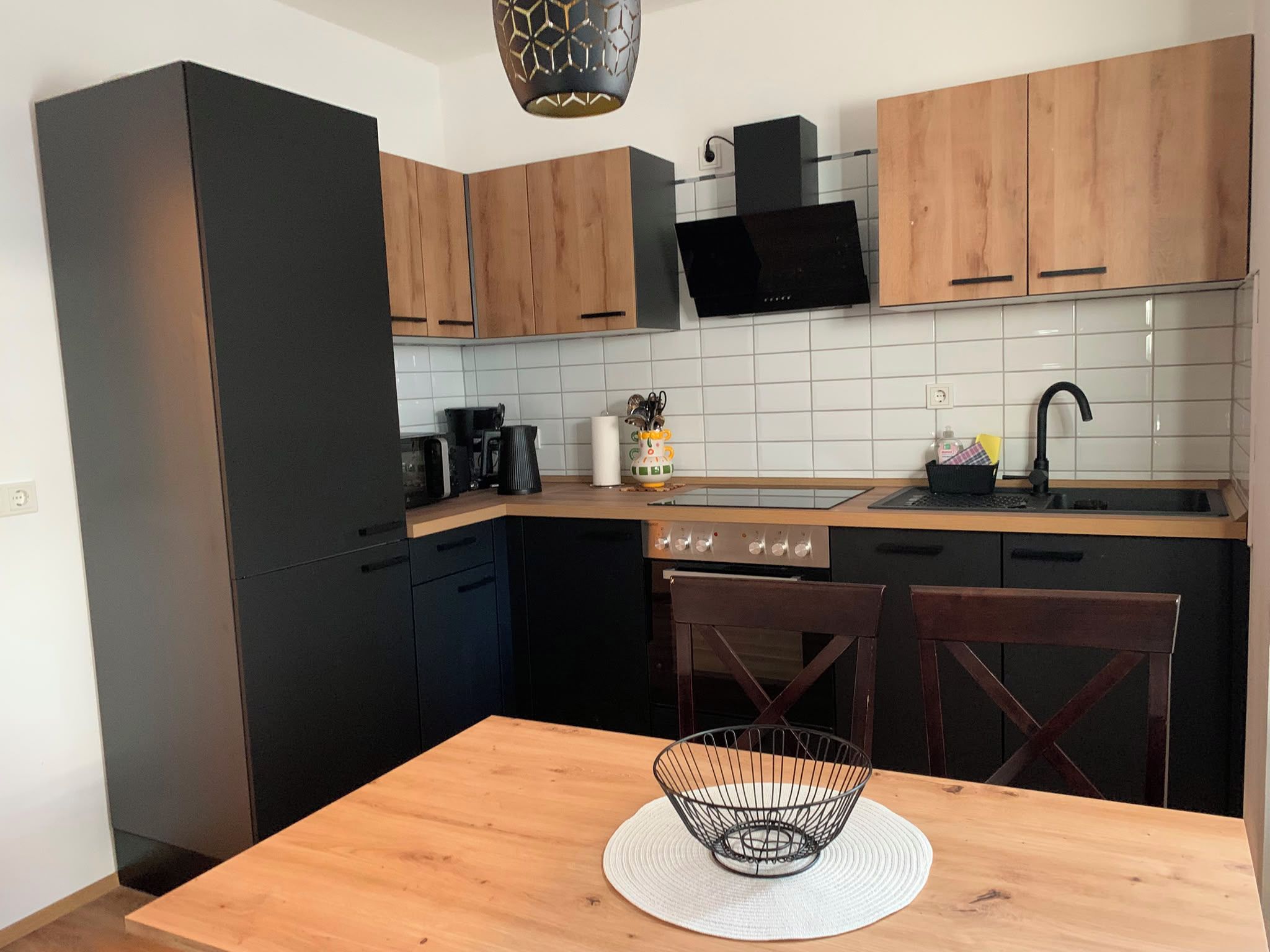Una cocina compacta con comedor, que incluye microondas, estufa y fregadero.