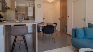 Ein modernes Apartment mit Küche, Essbereich und Wohnzimmer.
