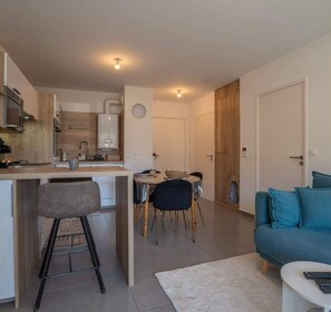 Ein modernes Apartment mit Küche, Essbereich und Wohnzimmer.