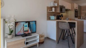 Eine moderne Küche mit Holzausstattung, einem eingebauten Backofen und einer kleinen Kücheninsel mit einem Stuhl.