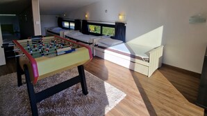 Ein Zimmer mit einem Kicker, einer Couch und einem Bett.