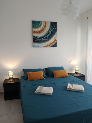 A bedroom with a bed, two nightstands, a wall art piece, and a ceiling fan. - Lovely 45M2+20M2 south-facing terrace apartment 400m from the beach and shops (San-Nicolao)