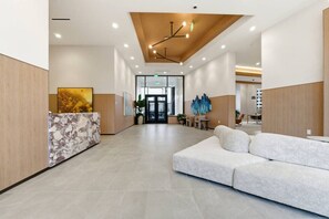A spacious lobby with a reception desk, seating area, and modern lighting. - Central & Comfortable Two Bedroom Two Bathroom (Cleveland)