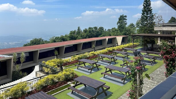 Terraza en la azotea con varias mesas de picnic y vista al paisaje.
