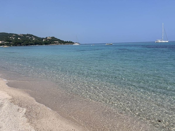 A beach with clear water, a sandy shore, and boats in the distance. - Beautiful apartment in Conca, private pool and 5-minute walk to the beach (Conca)
