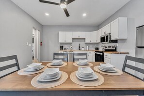 A modern kitchen with white cabinets, a microwave, and a refrigerator. - Cozy & Spacious Four Bedroom (Cleveland)