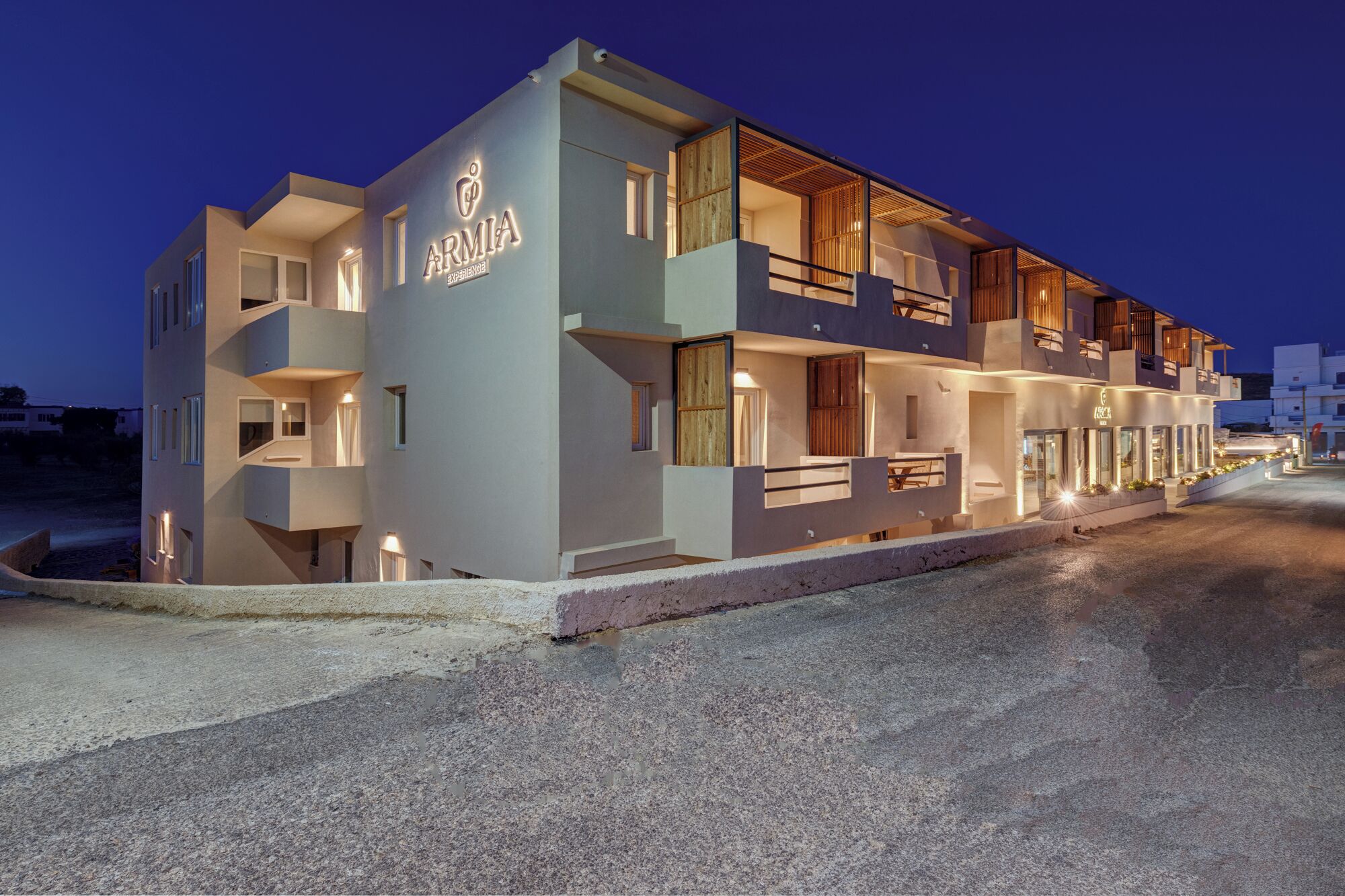 Un hotel modern amb façana plana, diversos balcons i una entrada ben il·luminada.
