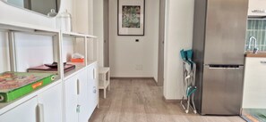 Eine Küche mit Kühlschrank, Spüle und einem Regal mit einem Gesellschaftsspiel.