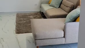 A modern living room with a sofa, two wall-mounted air conditioners, and a marble floor. - Beautiful house minutes from airport and beach (Carolina)