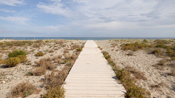 Un sendero de concreto que lleva a la playa.