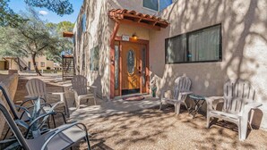 A building with a wooden door, outdoor seating, and a clear sky.