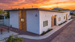 Un edificio moderno con techo plano, el número 1011 en la fachada y una ventana pequeña.