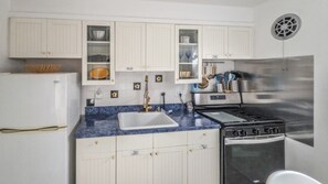 A kitchen with white cabinets, a blue marble countertop, a stainless steel stove, and a white refrigerator. - Belleview - Alexandria Condo (Alexandria)