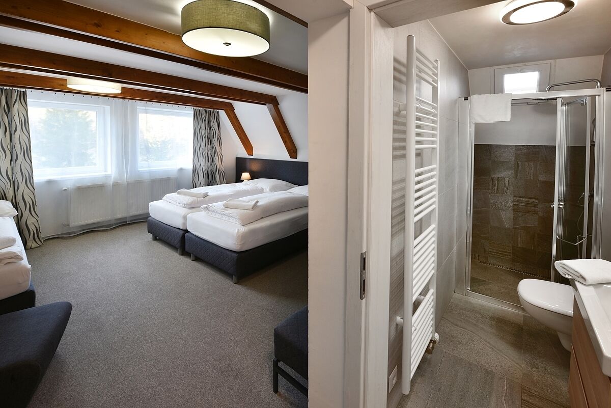 A bedroom with a bed, bedside tables, and a window with curtains.