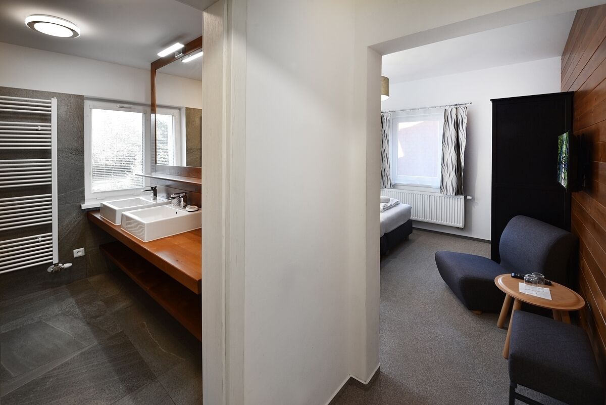 Une salle de bain moderne dotée d’un grand miroir, de deux vasques et d’un espace douche.
