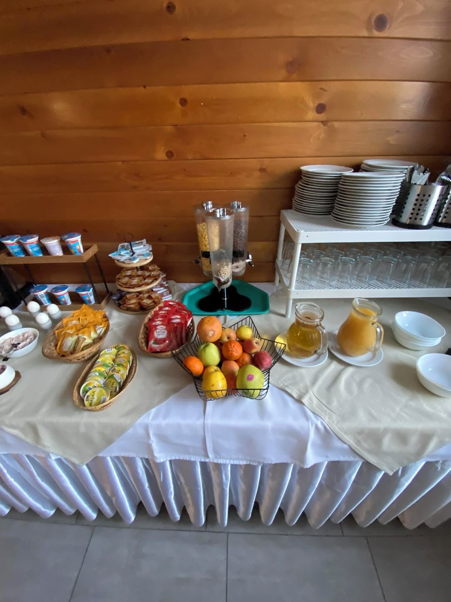 Ein reichhaltiges Buffet mit verschiedenen Speisen, darunter Obst, Brot und Getränke.