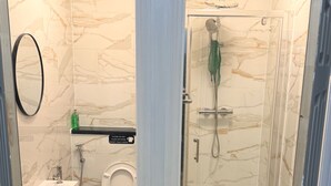 A bathroom with a toilet, sink, shower, and a glass-enclosed shower stall. - House Sleeps 2 With Parking (Croydon)