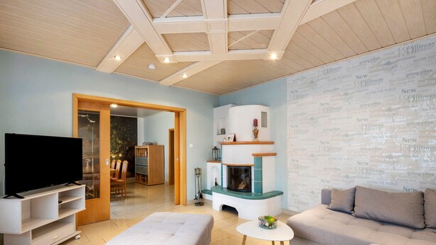 A living room with a flat-screen TV, a fireplace, a sofa, and a dining area. - Holiday Home 'Family House with Huge Garden' with Sauna, Terrace and Wi-Fi (Jessen (Elster))
