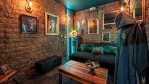Una habitación con pared de ladrillo, un sofá, una mesita de centro y un perchero.