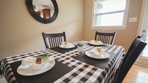 A dining table with a checkered tablecloth, four chairs, and plates with food and drinks. - Inviting Townhome in St. John's City Center! (St. John's)
