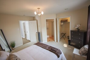 A bedroom with a bed, dresser, and a closet.