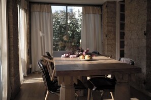 A dining table with chairs, a candle, and a plate of food. - Villa Alba, house with private access to the river, swimming and canoes (L'Isle-sur-la-Sorgue)