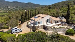 A house with a paved driveway, a parked camper van, and a view of the surrounding hills. - Il Cavaliere - Fantastic sea view, pool, beach only 5 minutes on foot (Lacona)