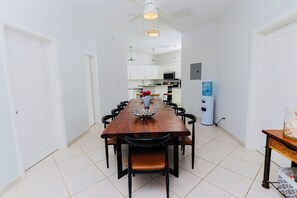 Un espace repas comprenant une table en bois, des chaises et un ventilateur de plafond.